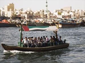 Abra water taxi with commuters crossing the Creek Souk market behind.