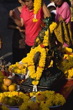 Women in pink to honour the King with Offerings on table for parade celebrating local temple.