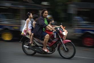 Mother with three young children on motorcycle.