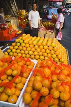 Stallholder attending oranges on stall for Chinese New Year.