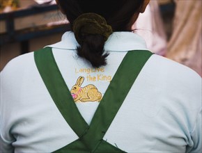 Thai woman wears shirt with Long live the King embroidery and Rabbit for year 2011 a symbol of peace.