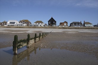 Seafront houses from beach with groyne in foreground.
