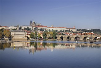 Charles Bridge and St Vitus seen from bank of River Vltava.