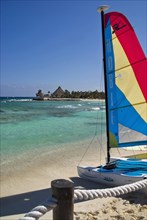 View along beach with colourful hobie cats.