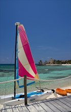 View over beach and bay with colourful hobie cat.
