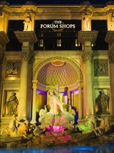 The Strip Caesars Palace Forum Shops exterior illuminated at night.