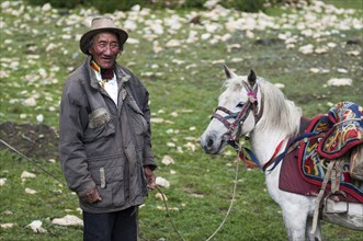 The portrait of a Nepalese high mountain nomad and his horse.