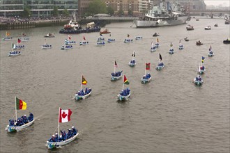 Flotilla of Sea Cadets in small boats proceeds along River Thames past HMS Belfast as part of the Queens Thames Diamond Jubilee Pageant taken from Tower Bridge 3rd June 2012.