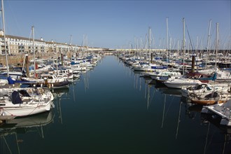 View over boats moored in the Marina with apartment buildings behind.