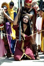 Philippines, Marinduque Island, Boac, Worshipper dressed as Christ carrying cross during the
