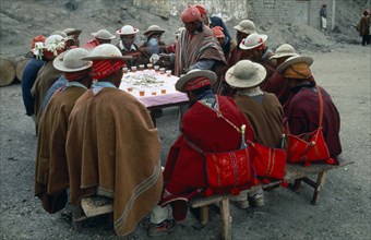Bolivia, La Paz, Amarete, Fiesta de San Felipe held on May 1st. Group of men sat around table being