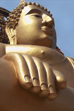 Thailand, Religion, Buddhism, Angled view of large golden seated Buddha statue. Photo : Derek