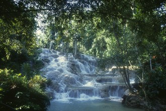 West Indies, Jamaica, Ocho Rios, Dunns River Falls. Waterfall tumbling over rocks surrounded by
