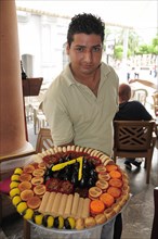Mexico, Veracruz, Sweet seller in the Zocalo displaying large plate with variety of sweets. Photo :