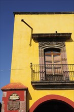 Mexico, Bajio, San Miguel de Allende, El Jardin Part view of yellow painted exterior facade of
