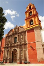 Mexico, Bajio, San Miguel de Allende, Exterior facade and bell tower of orange and yellow painted
