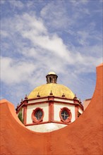 Mexico, Bajio, San Miguel de Allende, Dome of the Parroquia church part framed by orange painted