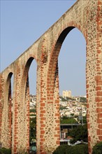 Mexico, The Bajio, Queretaro, Aquaduct arches framing view towards city buildings on hillside