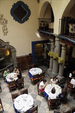 Mexico, Puebla, Looking down on diners in courtyard of Hotel Colonial. Photo : Nick Bonetti