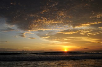 Mexico, Oaxaca, Puerto Escondido, Puerto Escondido Sunset over Playa Zicatela with waves breaking