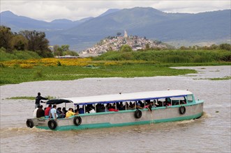 Mexico, Michoacan, Patzcuaro, Crowded passenger boat on Lago Patzcuaro with Isla Janitzio beyond.