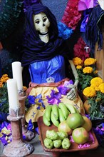 Mexico, Michoacan, Patzcuaro, Dia de los Muertos Day of the Dead altar with figures food candles