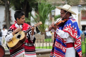 Mexico, Michoacan, Patzcuaro, Musicians playing violin and guitar during performance of Danza de