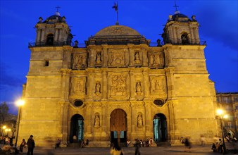 Mexico, Oaxaca, Baroque exterior facade of the Cathedral at night with people in the square in