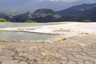 Mexico, Oaxaca, Hierve el Agua, Mountainous landscape with limestone pools in the foreground. Photo