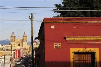 Mexico, Oaxaca, View towards church of Santo Domingo from street corner and red and ochre painted
