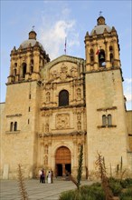 Mexico, Oaxaca, Church of Santo Domingo exterior facade and bell towers with small group of people