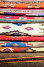 Mexico, Oaxaca, Detail of stacked weavings and carpets by Tomas and Arnulfo Mendoza. Photo : Nick