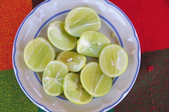 Mexico, Oaxaca, Huatulco, Blue and white bowl with cut halves of limes on red and green woven cloth