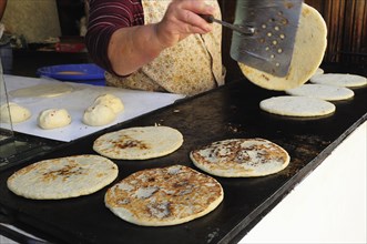 Mexico, Bajio, San Miguel de Allende, Cropped shot of woman making tortillas turning them as they