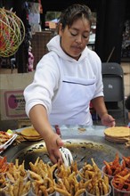 Mexico, Michoacan, Patzcuaro, Young woman frying fish. Photo : Nick Bonetti