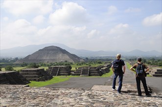 Mexico, Anahuac, Teotihuacan, Tourist couple taking in the view towards Pyramid del Sol.. Photo :