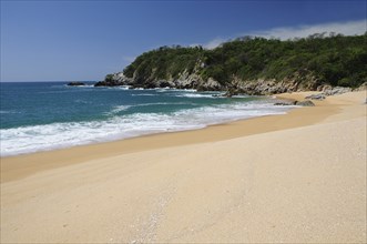 Mexico, Oaxaca, Huatulco, Playa Conejos Deserted beach with turquoise sea breaking on sandy shore