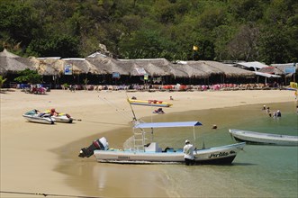 Mexico, Oaxaca, Huatulco, Tour boats and beach side restaurants on Playa La Entrega. Photo : Nick