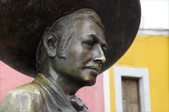 Mexico, Bajio, Guanajuato, Bronze statue of Charro singer Jorge Negrete with pink and yellow