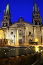Mexico, Jalisco, Guadalajara, Fountain in foreground of cathedral exterior facade and bell towers