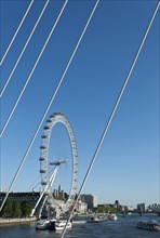England, London, London Eye at the Millennium Pier seen through the supports of Hungerford bridge.