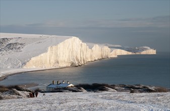 England, East Sussex, Seven Sisters, Snow covered coastline from Birling gap showing the coastguard