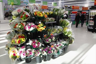 England, Shopping, Supermarket, Bunches of fresh flowers for sale by entrance. Photo : Sean Aidan
