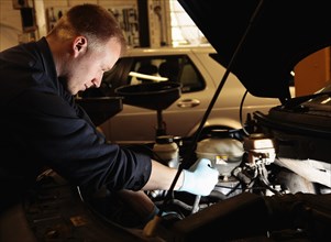 Transport, Road, Cars, Repair mechanic working on car in garage. Photo : Sean Aidan