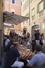 Italy, Lazio, Rome, Diners eating al fresco at a restaurant in back street. Photo : Bennett Dean