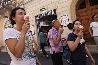 Italy, Lazio, Rome, Eating ice cream outside a Gelateria in a back street. Photo : Bennett Dean