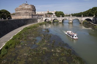 Italy, Lazio, Rome, Tourist boat on the Tiber River in front of the Bridge of Ponte Sant Angelo &