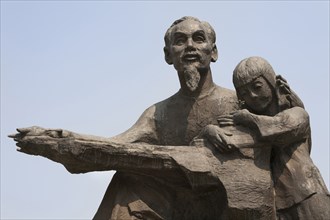 Vietnam, Ho Chi Minh City, Statue of Ho Chi Minh holding a child outside the Peoples Committee