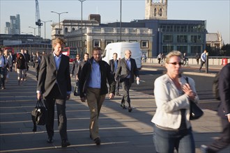 England, London, Early morning commuters crossing London Bridge towards the City Financial district