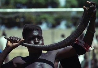 Kenya, Music, Man using animal horn as musical instrument. Photo : Hutchison